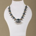 silver replica necklace set with green and mustard stones and pearl detailing by Khallaq